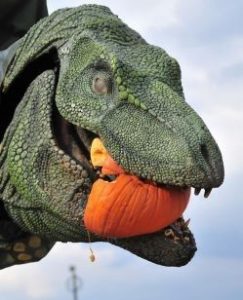T-Rex statue with pumpkin in mouth